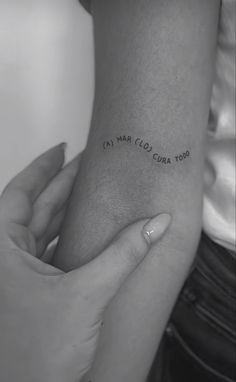 a woman holding her arm with the words lost and love written on it in cursive font