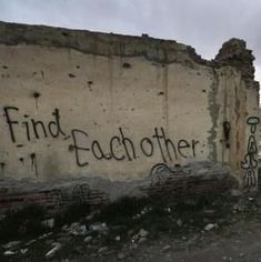 graffiti on the side of a building that says find eachother in black writing