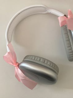 a pair of headphones sitting on top of a white table next to a pink ribbon