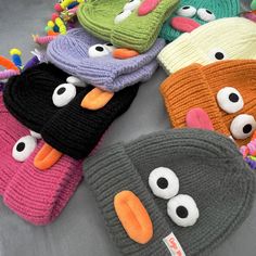 several knitted hats with googly eyes on them