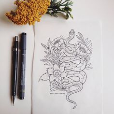 a drawing on paper next to a pen and flower with an inking pen in it