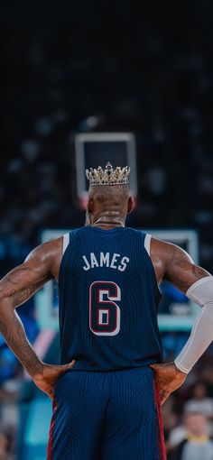 a man with a crown on his head is standing in front of a basketball hoop