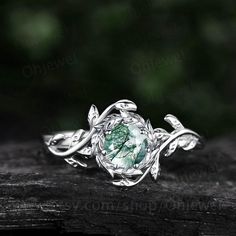 a green ring with leaves on it sitting on top of a piece of drift wood