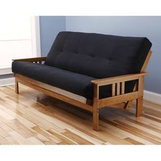 a futon bed frame in a room with hard wood flooring and blue walls