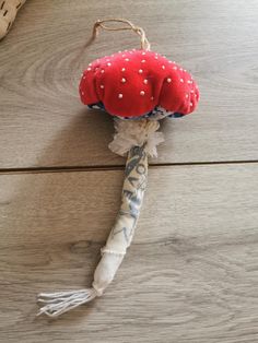 a red and white stuffed mushroom sitting on top of a wooden floor next to a bag