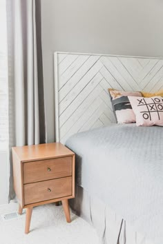 a bedroom with a bed, nightstand and window