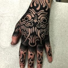 a person's hand with black and white tattoos on it, showing the intricate design