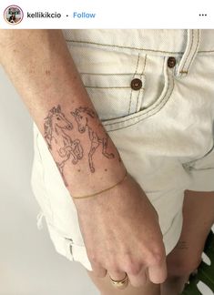 a person with a horse tattoo on their left arm and the other hand behind her