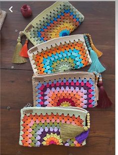 three crocheted bags with tassels on them