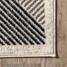 a black and white rug on top of a wooden floor