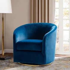 a blue chair sitting on top of a rug next to a lamp