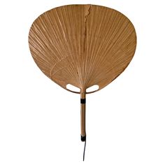 a large bamboo fan with black handles on a white background in the shape of a leaf