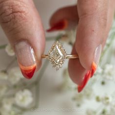 a close up of a person's hand holding a diamond ring