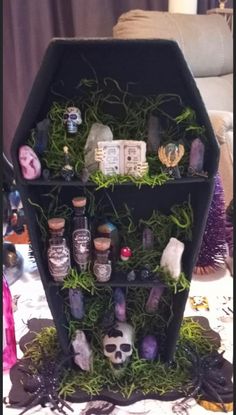 a shelf filled with bottles and plants on top of a table