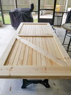 a table made out of wooden boards in a room with chairs and tables around it