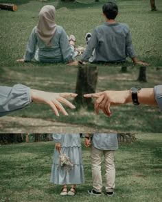 two people sitting in the grass with their hands extended out to touch each other's fingers