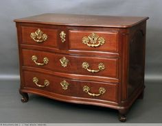 an antique chest of drawers with gold handles and knobs on the front, in mahogany wood