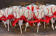 several lollipops wrapped in cellophane and tied with red ribbon on a wooden table