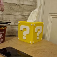 a cell phone sitting on top of a table next to a tissue dispenser