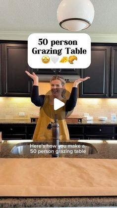 a woman standing in front of a kitchen counter holding up a sign that says 50 person grating table