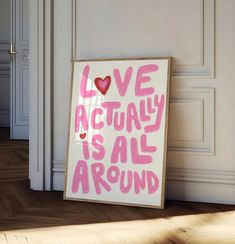 a sign that says love actually is all around on the floor in front of a door