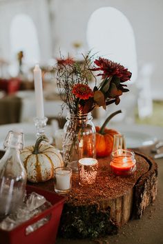 a table with candles, flowers and pumpkins on it