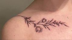 a woman's chest with flowers and leaves tattoo on the left side of her shoulder