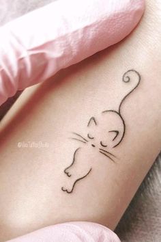 a small cat tattoo on the left thigh and right leg, with a black outline