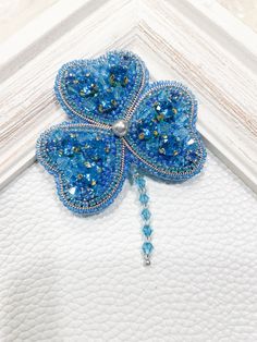 a close up of a blue brooch with beads