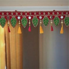 a red and green curtain with tassels hanging from it