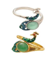 three rings with green and blue designs on them, one in the shape of a bird