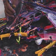 a person is painting on the ground with paintbrushes and other things around them