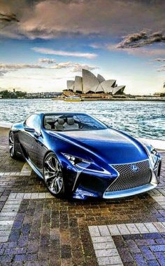 a blue sports car parked in front of the sydney opera