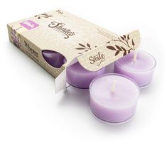 three purple candles sitting in front of a box