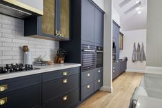 a kitchen with blue cabinets and white counter tops, gold trim on the doors is shown