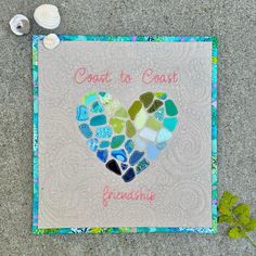 a heart made out of sea glass sitting on the ground