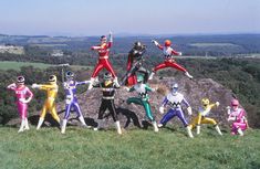 the power rangers are posing on top of a hill