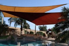 an outdoor swimming pool with sun shade over it