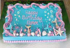 a birthday cake decorated with sea animals and seashells