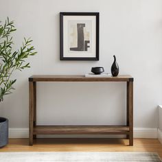 a wooden table sitting next to a potted plant on top of a hard wood floor