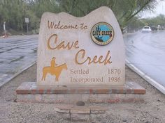 the welcome sign to cave creek is located on the side of the road