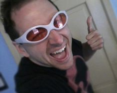 a man wearing sunglasses giving the thumbs up