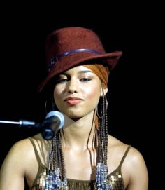 a woman wearing a brown hat while holding a microphone