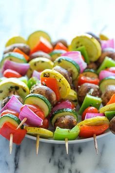 several skewered vegetables are in a white bowl