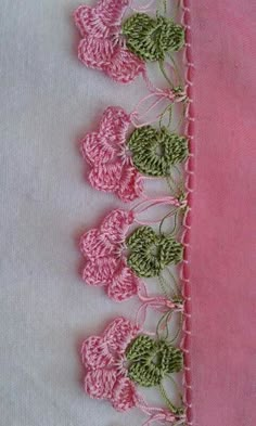 pink and white table cloth with green flowers on the edge, in front of a light pink background