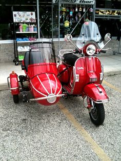 a red motor scooter parked on the street