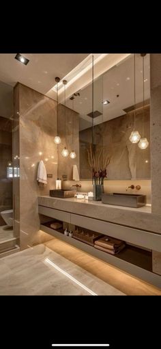 a bathroom with a large mirror and lights on the wall