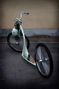 an old style scooter is parked on the side of the road with no wheels