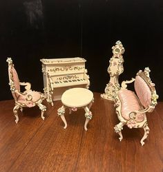 three miniature furniture sitting on top of a wooden table next to a small white piano