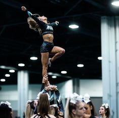 the cheerleader is doing tricks on the pole